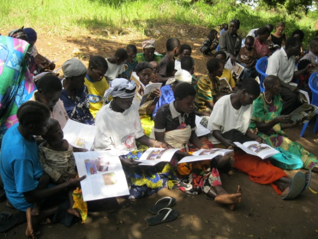 Women in Lukodi reading the new report on the Lukodi massacre